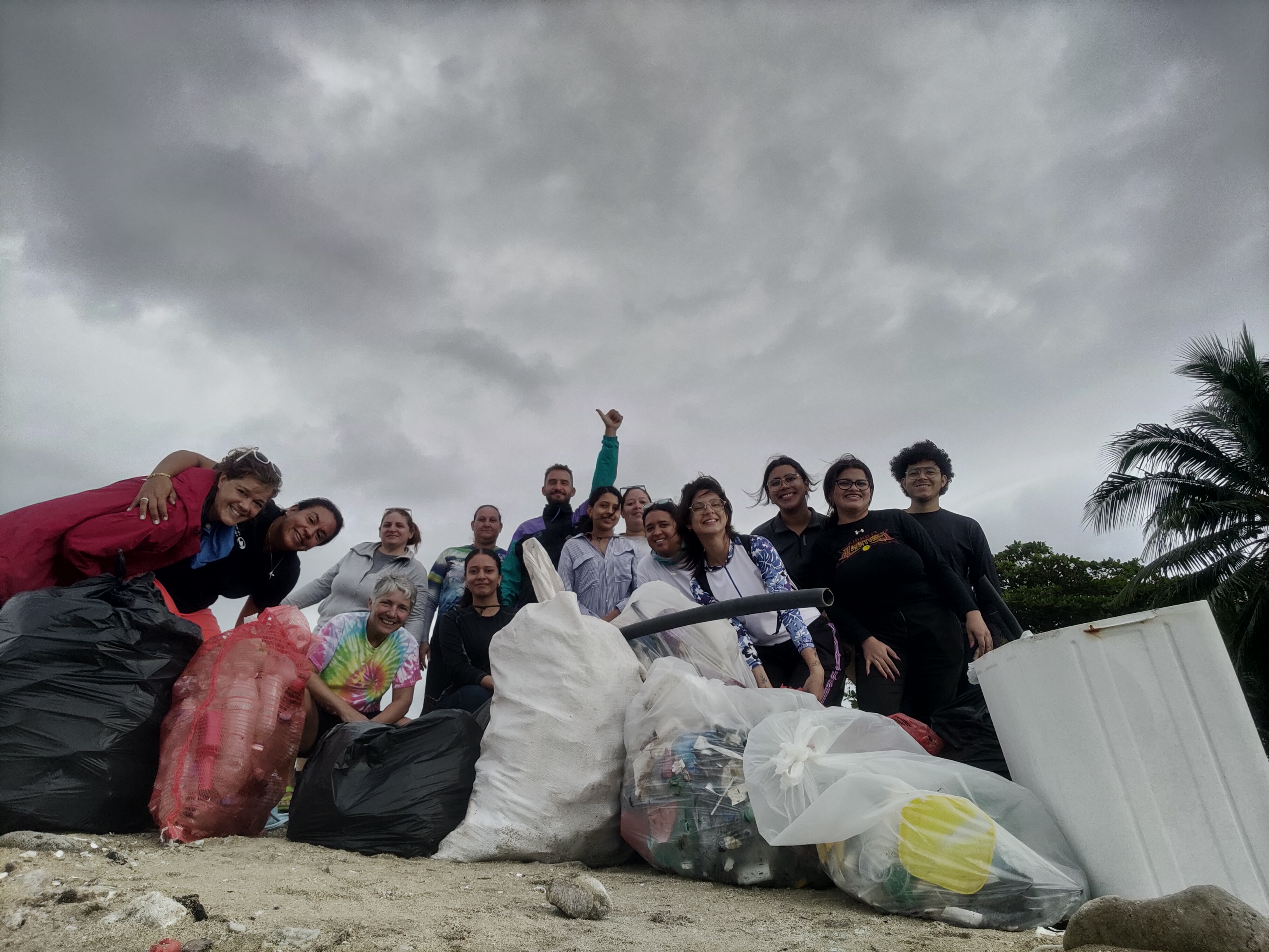 Cleanup crew poses under a cloudy sky at Coco Beach on February 4th 2026.